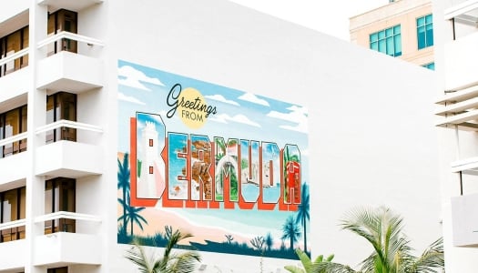 A sign painted on the side of a building that says "Greetings from Bermuda".