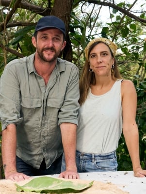 A man and woman are posing in front of Art.