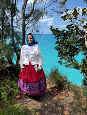 A woman is posing in traditional portuguese regalia.