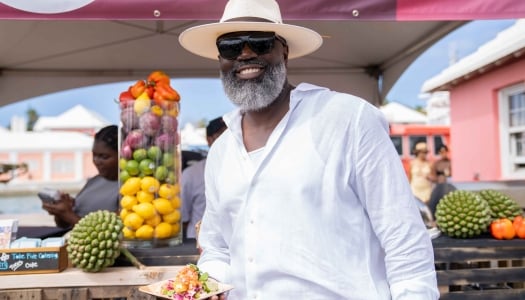 A man is posing while holding a plate of food.