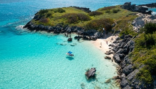 An aerial of a boston whaler and a family on the beach.