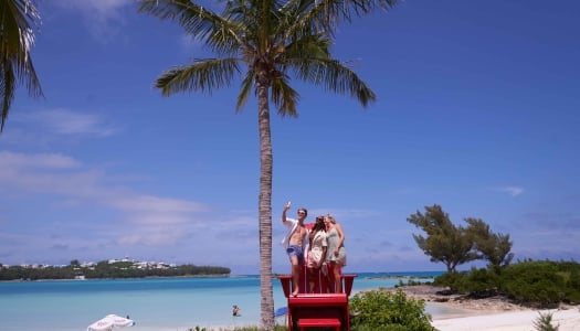 A group of friends are posing on a chair.