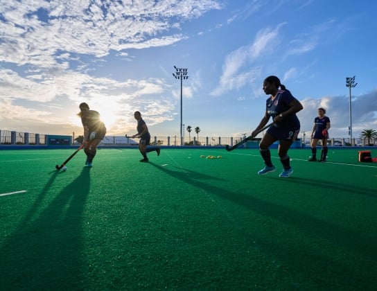 A group of women are playing field hockey