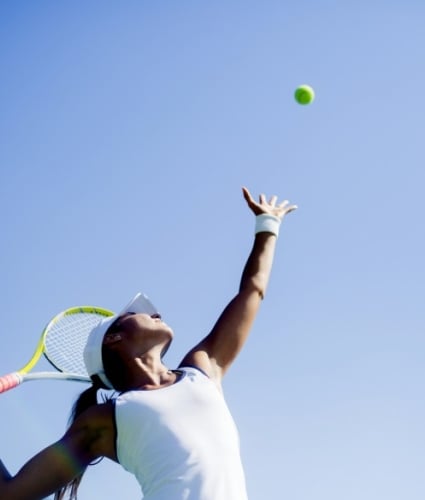 tennis player serving ball